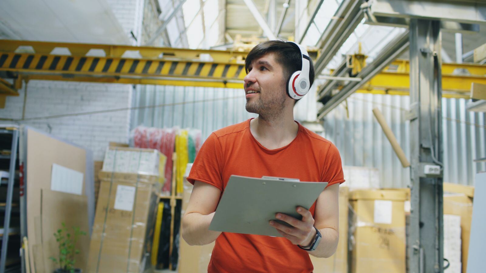 Warehouse Worker with Headphones and Clipboard